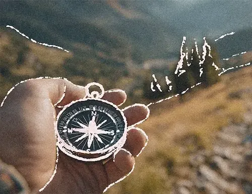 a compass in hand with view of nature