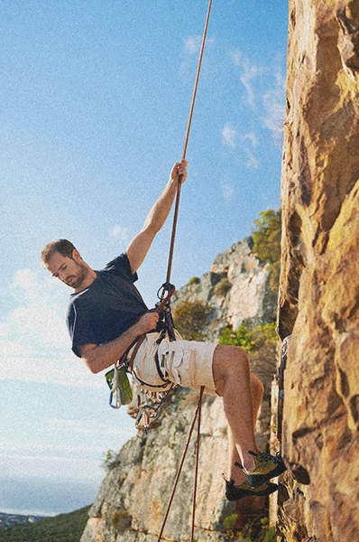 man climbing the side of a cliff