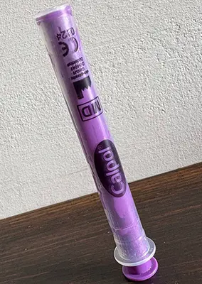 A calpol syringe balanced upright on its side