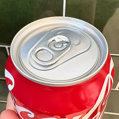 A can of coca cola from above, showing the lip and pop tab