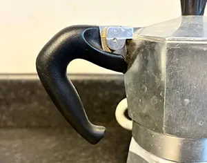 A close up of the moka pots handle